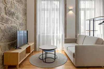 a living room with a couch and a tv at Filigrana Apartments in Porto