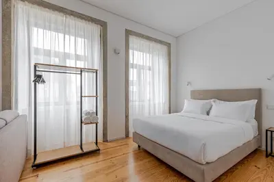 a white bedroom with a bed and a couch at Filigrana Apartments in Porto