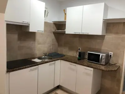 a kitchen with white cabinets and a microwave on a counter at Nice Belmonte Flat in Porto