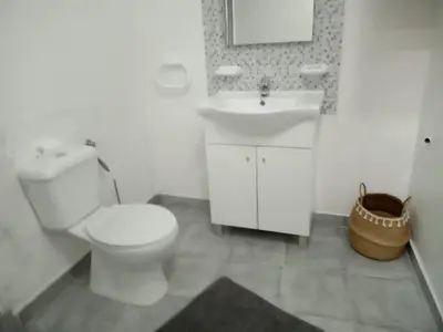 a white bathroom with a toilet and a sink at Nice Belmonte Flat in Porto