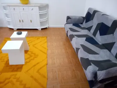 a living room with a couch and a yellow rug at Nice Belmonte Flat in Porto