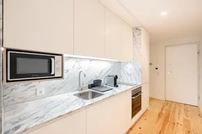 a kitchen with a sink and a tv on a counter at VIVA Central Downtown Studio in Porto