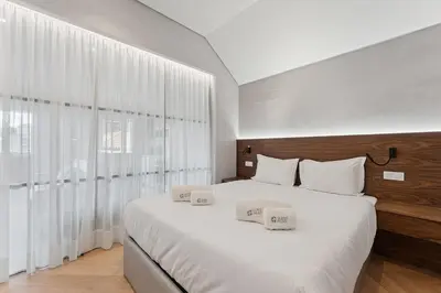 a bedroom with a large white bed with two towels on it at GuestReady - Stylish base steps from attractions in Porto