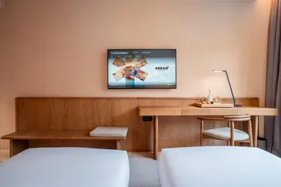 a hotel room with a desk and a tv on the wall at Akeah Porto Centro in Porto