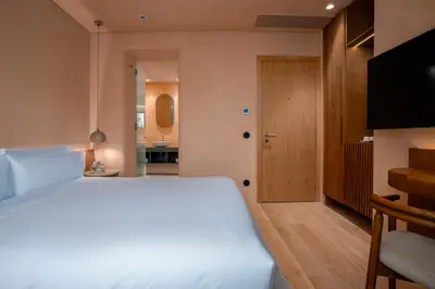 a bedroom with a large white bed and a bathroom at Akeah Porto Centro in Porto