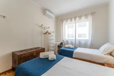 a bedroom with two beds and a desk and a window at GuestReady - Home Comforts in Porto in Porto