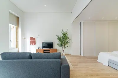 a living room with a couch and a tv at Bright Studio in Porto in Porto