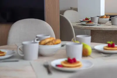 a table with plates of food on top of it at Stylish & Cozy 1BR with AC by LovelyStay in Porto