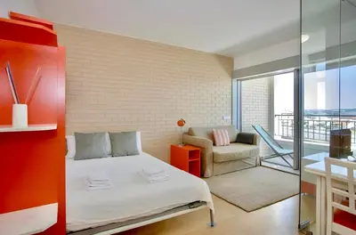 a bedroom with a bed and a chair and a balcony at Oporto Blue Dragão - Modern Uptown Studio With Free Parking in Porto