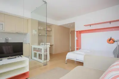 a bedroom with a bed and a tv and a table at Oporto Blue Dragão - Modern Uptown Studio With Free Parking in Porto