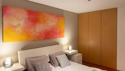 a bedroom with a large painting above a bed at Porto H Dragão in Porto