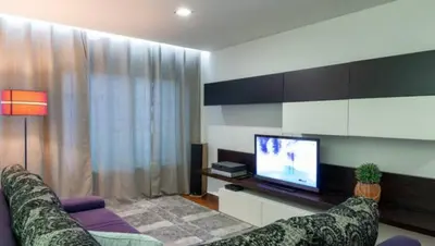 a living room with a couch and a tv at Porto H Dragão in Porto