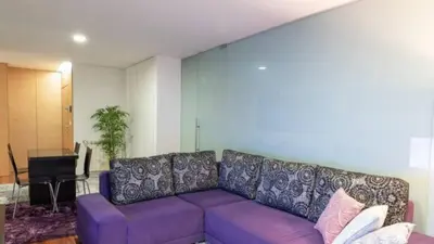a purple couch in a living room with a piano at Porto H Dragão in Porto