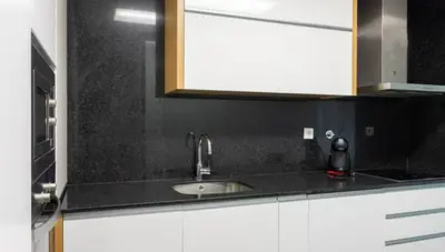 a kitchen counter with a sink and a mirror at Porto H Dragão in Porto