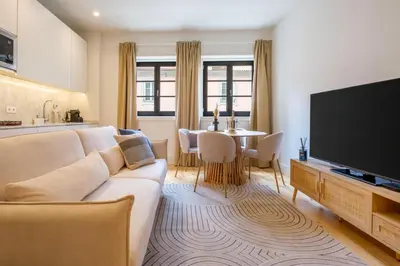 a living room with a white couch and a television at Art Deco 14 Luxury Apartment Downtown Metro AC in Porto