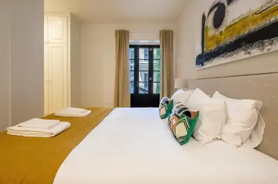 a bedroom with a large bed with white pillows at Art Deco 14 Luxury Apartment Downtown Metro AC in Porto