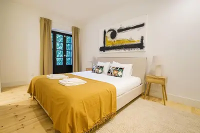 a bedroom with a bed with a yellow blanket at Art Deco 14 Luxury Apartment Downtown Metro AC in Porto