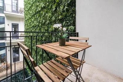 a wooden table and chairs on a balcony at Art Deco 24 Luxury Apartment Downtown Metro AC in Porto