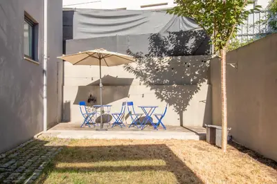 a patio with a table and an umbrella at Chic Campanhã Home w Free Parking by LovelyStay in Porto