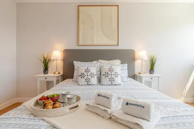a bedroom with a bed with a tray of fruit on it at Stylish Home with Balcony & Garage by HostWise in Porto