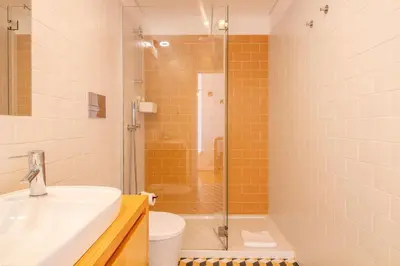 a bathroom with a shower and a sink and a toilet at Stylish & Sunny 2BR near Heroísmo by LovelyStay in Porto