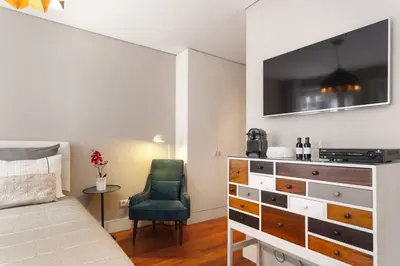 a bedroom with a bed and a dresser and a chair at Luxury Apartment In Cardosas in Porto