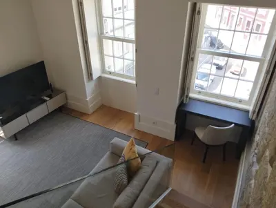a living room with a couch and two windows at Timeless Elegance Boutique for two in Porto