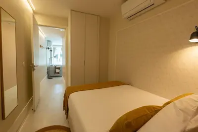 a small bedroom with a bed and a hallway at Porto Haven - Under the Luís I Bridge in Porto