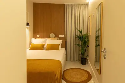 a hotel room with a bed with yellow pillows at Porto Haven - Under the Luís I Bridge in Porto
