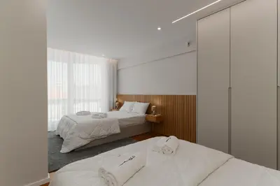 a bedroom with a large bed and a large window at O Navegador in Porto