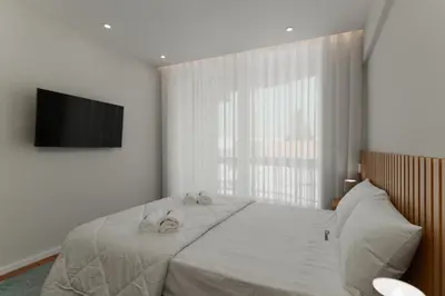 a bedroom with a bed with two towels on it at O Navegador in Porto