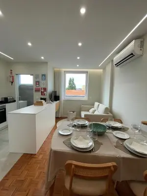 a kitchen and living room with a table and chairs at O Navegador in Porto