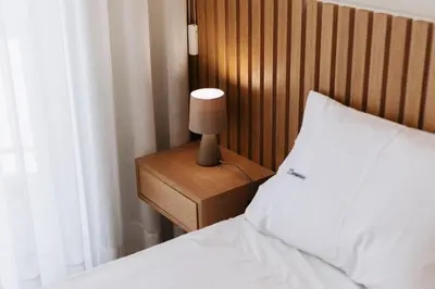 a bedroom with a bed and a lamp on a night stand at Fernão de Magalhães in Porto