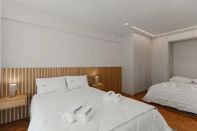 a bedroom with a large white bed with towels on it at Fernão de Magalhães in Porto