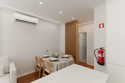 a room with a table with chairs and a fire extinguisher at Fernão de Magalhães in Porto