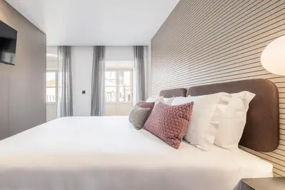 a bedroom with a large white bed with pillows at Aspasios Baixa Apartments in Porto