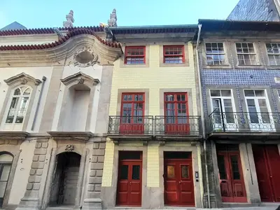 a row of houses with red doors and windows at Aspasios Baixa Apartments in Porto