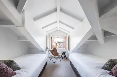 two beds in a room with white ceilings at Aspasios Baixa Apartments in Porto