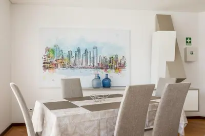 a dining room table with chairs and a painting on the wall at Apartamento de luxo Centro do Porto - ACE Residence in Porto