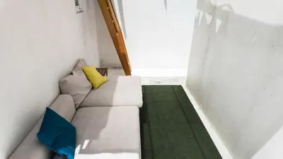a white couch with two pillows sitting in a room at Bonfim Residence in Porto