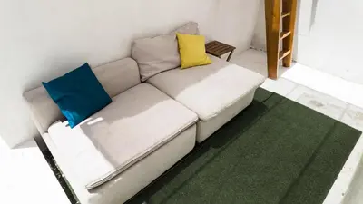 a white couch with two colorful pillows on it at Bonfim Residence in Porto