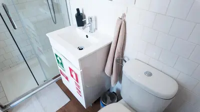 a bathroom with a toilet and a sink and a shower at Bonfim Residence in Porto