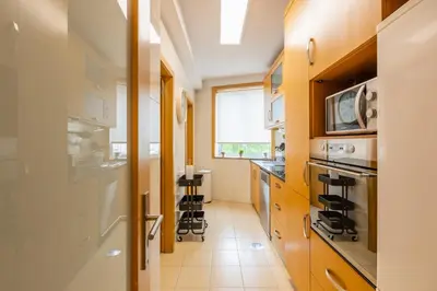 a kitchen with wooden cabinets and a window at Porto Stay no Marques with AC and parking place in Porto