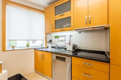 a kitchen with wooden cabinets and a sink at Porto Stay no Marques with AC and parking place in Porto