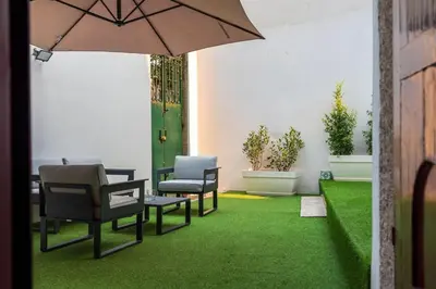a patio with chairs and an umbrella and grass at Central Porto Hideaway with Sunny Terrace by Lisbeyond in Porto