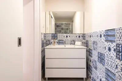 a bathroom with a sink and blue and white tiles at Central Porto Hideaway with Sunny Terrace by Lisbeyond in Porto