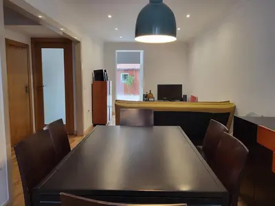 a dining room with a black table and chairs at Casa da travessa familial e com terraço in Porto