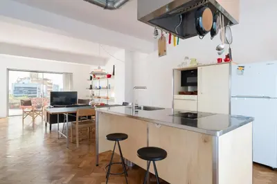 a kitchen and dining room with a counter and stools at Stylish Flat w/ Terrace & Views by HostWise in Porto