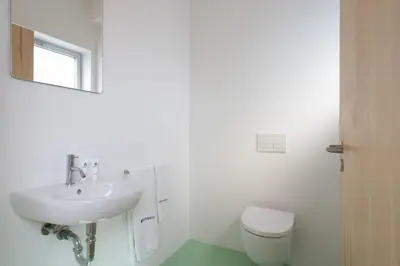 a white bathroom with a sink and a toilet at Stylish Flat w/ Terrace & Views by HostWise in Porto