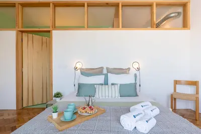 a bed with towels and a tray of fruit on it at Stylish Flat w/ Terrace & Views by HostWise in Porto